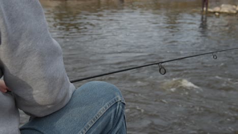 a man sitting and fishing on the miracle mile in wyoming