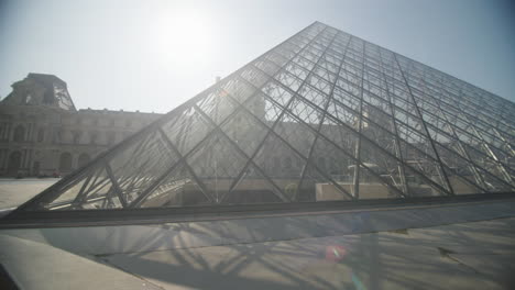 panning left outside famous glass pyramid of the louvre in paris, france