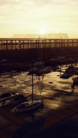 sunset boats docked reflections on calm water by waterfront