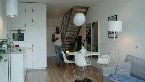 man using mobile phone in a modern apartment kitchen