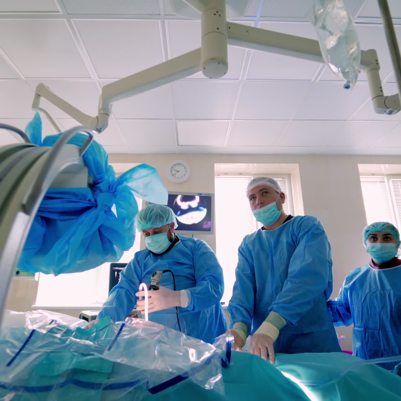 Medical team performing surgical operation in bright modern surgery room. Operating theatre. Modern equipment in clinic