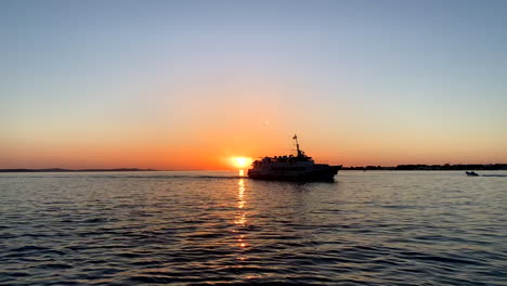 a boat drives during the sunset