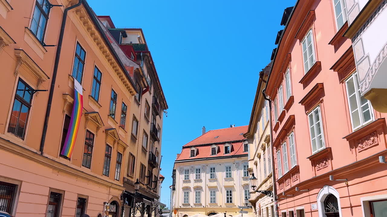 Bratislava, Slovakia, 2 June 2025: Bright summer sun lights the facades of the beautiful buildings. A walk by the cozy street in the old town of Bratislava, Slovakia