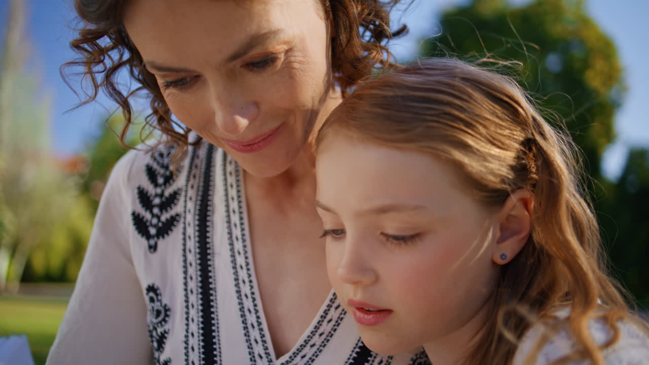 Closeup mom kid bonding resting park on sunny lawn. Happy family summer weekend