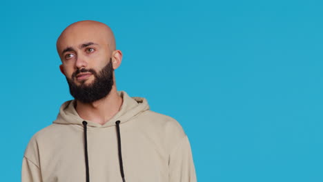 middle eastern serious adult posing on studio backdrop