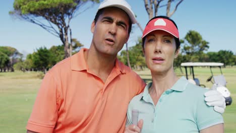 happy couple interacting with each other while playing golf