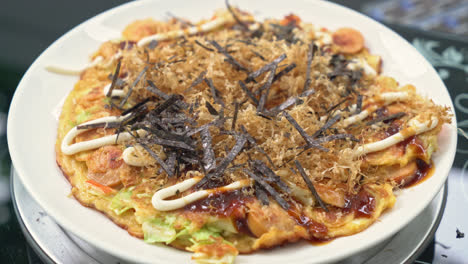 putting seaweed on okonomiyaki or japanese pizza