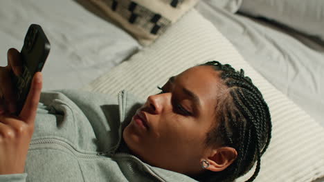 adolescente usando el teléfono inteligente en la cama por la noche