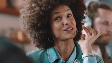 beautiful mixed race woman with afro hairstyle chatting with friend in cafe socializing enjoying conversation hanging out in restaurant