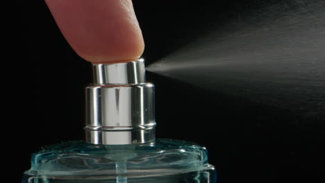 young man applying perfume to skin in the dark, close up of spraying deodorant luxury perfume.