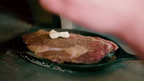 close up view of steak on the cast-iron skillet over high heat