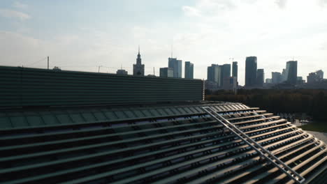 Ascending-footage-along-building-wall-with-windows.-Revealing-Pilsudski-Square-and-skyline-with-high-rise-buildings.-Warsaw,-Poland