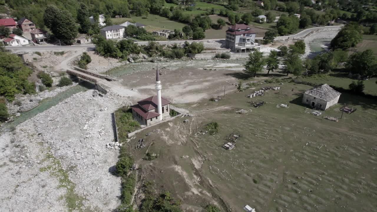 Video drone con ripresa a spirale su una chiesa ortodossa situata sulla riva del fiume nella valle di Valbona, Albania, Contea di Margegaj.