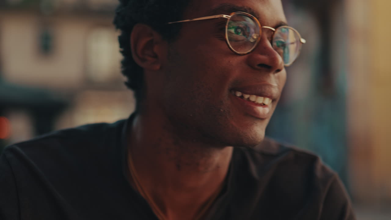 Close-up of Thoughtful African American Man in Glasses Smiling Outdoors
