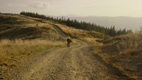 Mujer-En-Bicicleta-Bajando-Por-Una-Carretera-De-Montaña.-Pareja-De-Ciclistas-Entrenando-Juntos