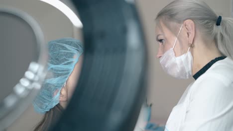 brow master applies paint on beautiful girl face in salon