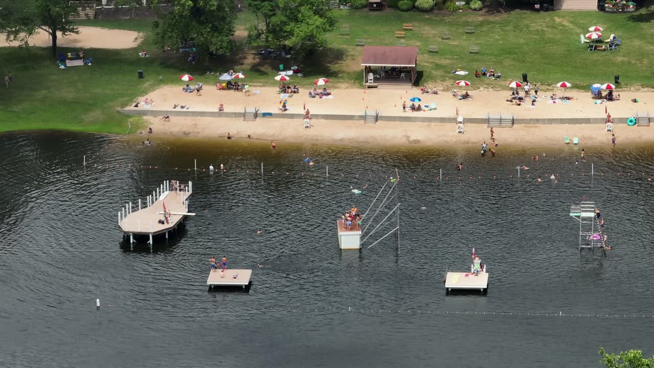 Aerial view of sandy beach with resting people at american lake in Mount Gretna. Drone top down.