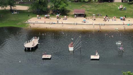 aerial view of sandy beach with resting people at american lake in mount gretna. drone top down.