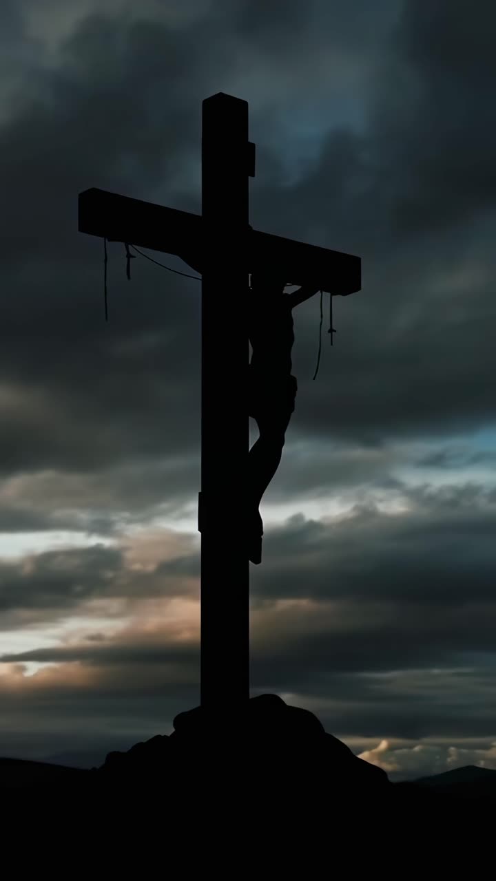 Silhouette di una croce al tramonto, ripresa dal basso, che crea una scena video drammatica.