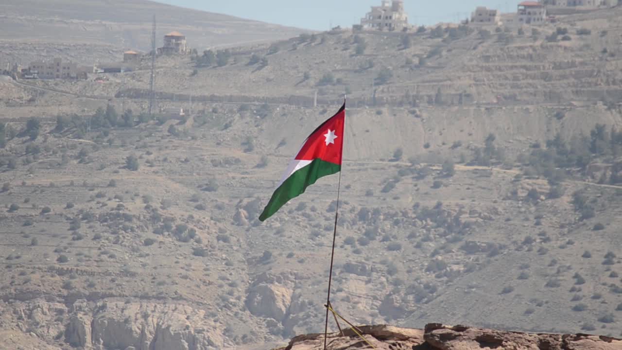 Jordanian flag flying above ancient city Petra