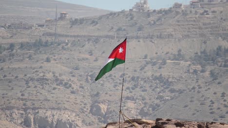 jordanian flag flying above ancient city petra