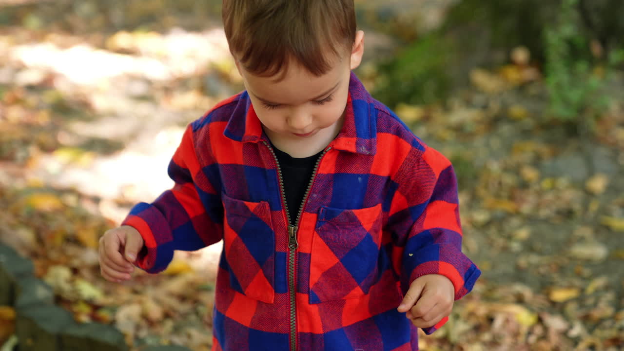Striped cloth wearing kid playing. Small stylish boy outdoor walking.