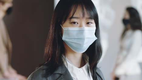 portrait of asian businesswoman in mask on conference