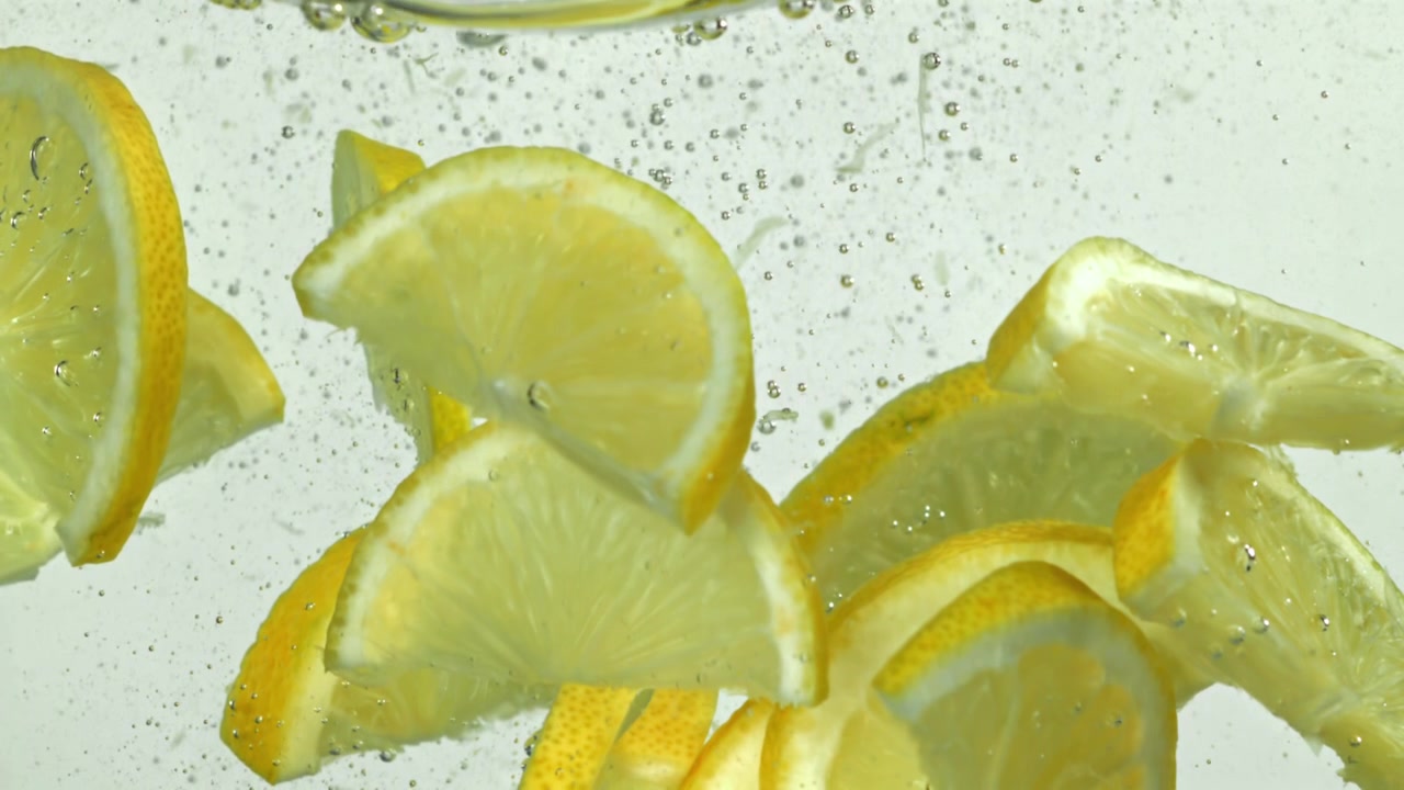 Fette di limone fresche che galleggiano in acqua frizzante