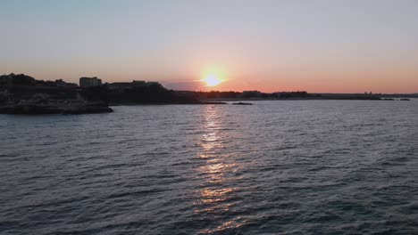 Aerial-shot-of-sunset-above-the-port-Lozenets-,-Bulgaria,-filmed-by-drone-lifting-up-from-the-water