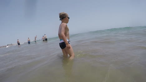 child bathing in the sea and jumping with wave