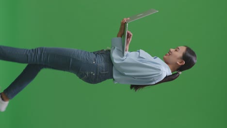 스튜디오에서 녹색 화면 배경에서 는 동안 노트북 컴퓨터를 사용하는 아시아 사업가의 측면 시각