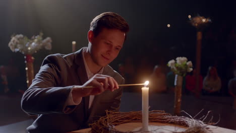 man lighting candle in a ceremony
