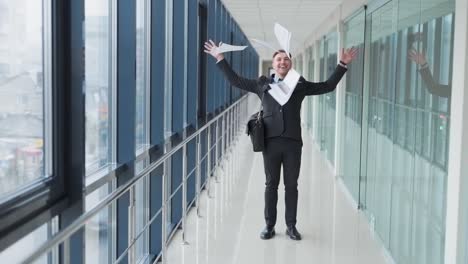 confident young businessman leaving office tosses papers and goes forward