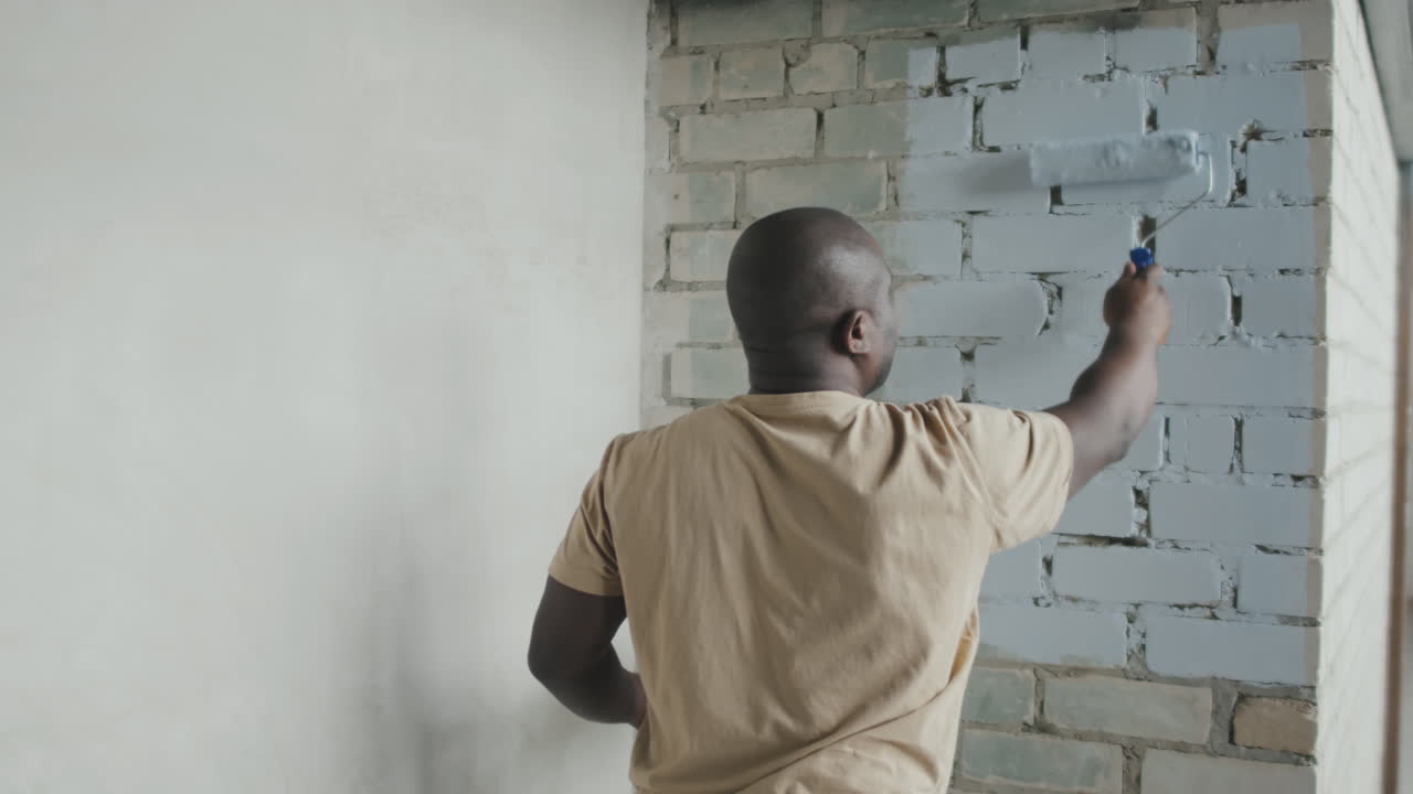 Man painting a brick wall