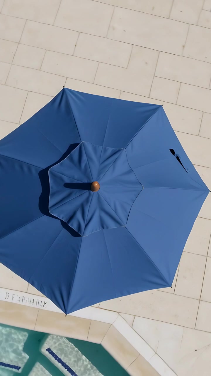 Video verticale: Rivelando un ombrellone blu da patio mentre la telecamera panoramica sulla piscina, mostrando il bordo e il puntale.
