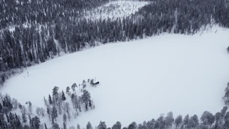 Drohnenaufnahme-Eines-Gefrorenen-Sees-Und-Schneebedeckter-Wälder-In-Der-Natur-Lapplands