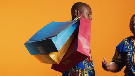 Bored-boyfriend-carrying-shopping-bags-for-his-girlfriend