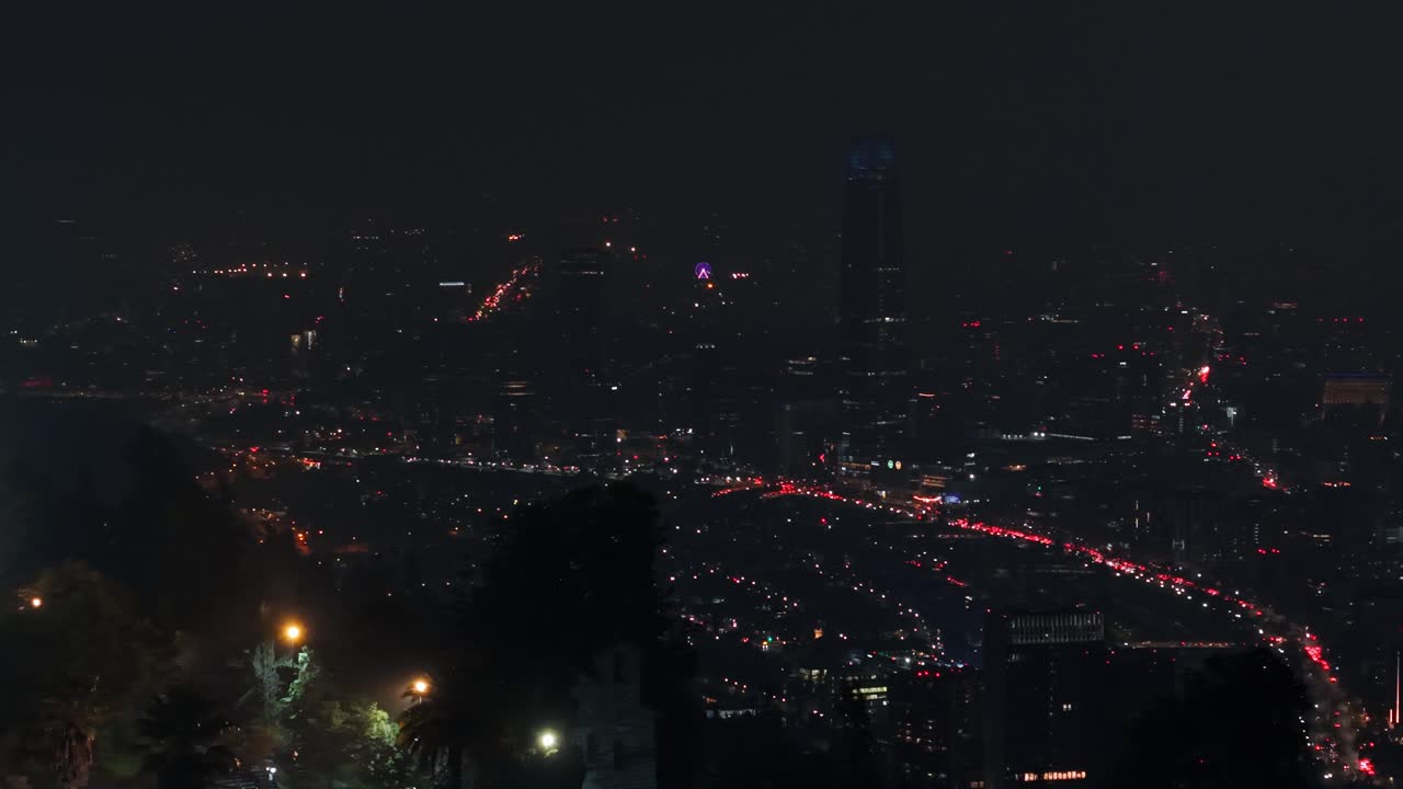 A smooth night pan of Santiago, Chile, showing city lights and glowing traffic streams
