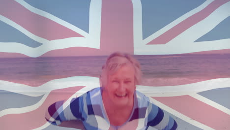 lächelnde frau am strand mit union jack-flaggenanimation im hintergrund