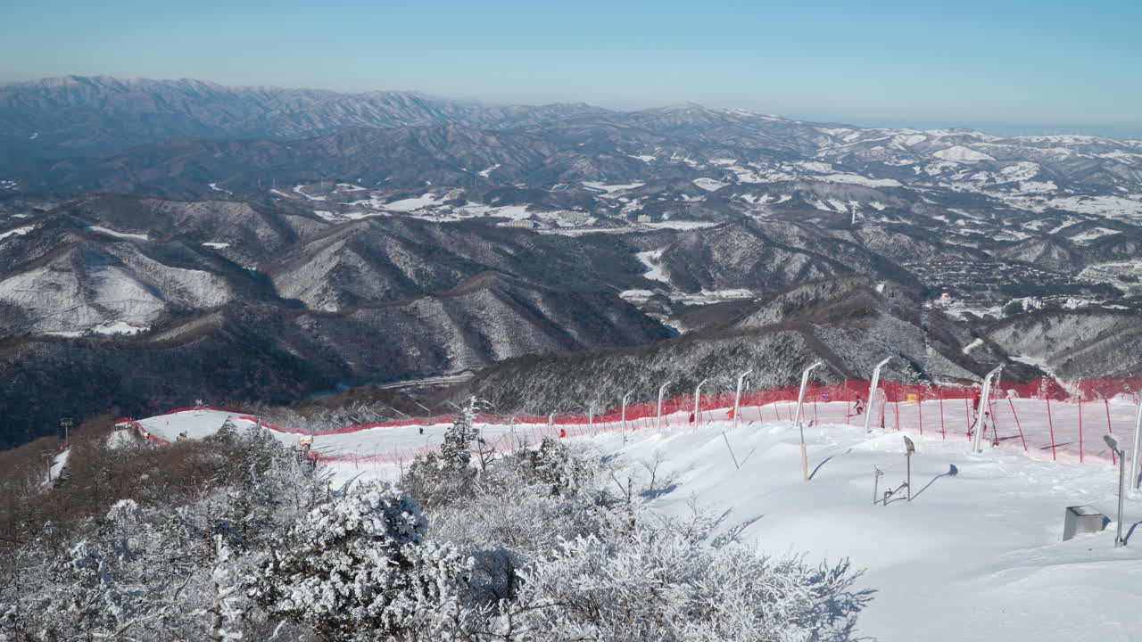 Majestic Gangwon-do Mountains Winter Panorama and People Skiing Downhill of Balwangsan Mountain Slopes in Yong Pyong Ski Resort Pyeongchang-gun - slow motion pan
