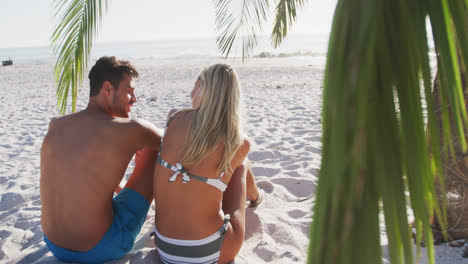 una pareja caucásica disfrutando del tiempo en la playa.