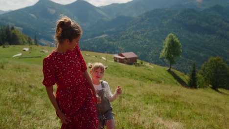 mother speaking daughter walking on green hill. girl enjoying holiday with mom.