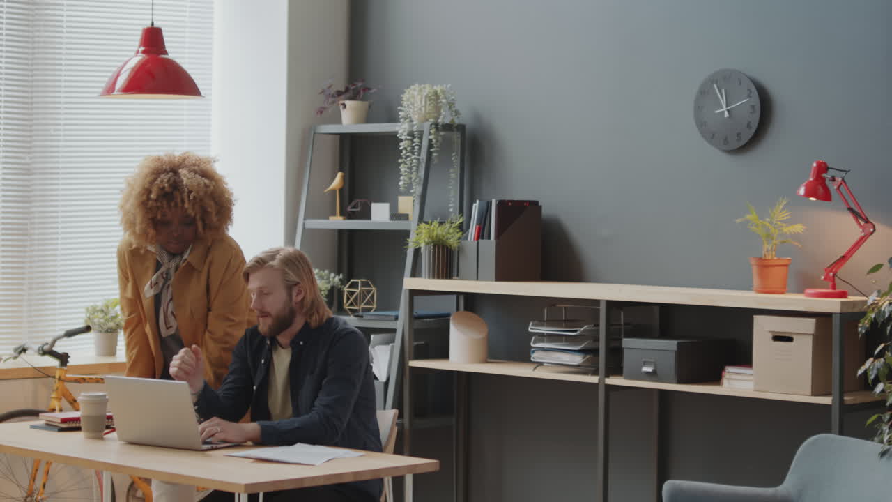 Caucasian Man and African American Woman Cooperating in Office