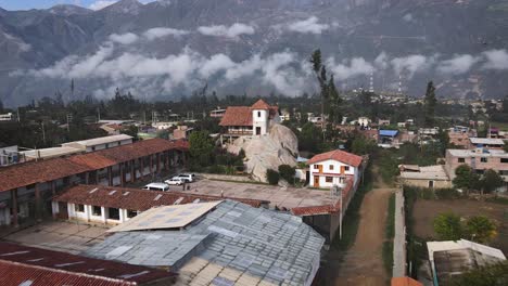 pull away drone shot of a curch on top of a rock located in a small city in the highlands of peru