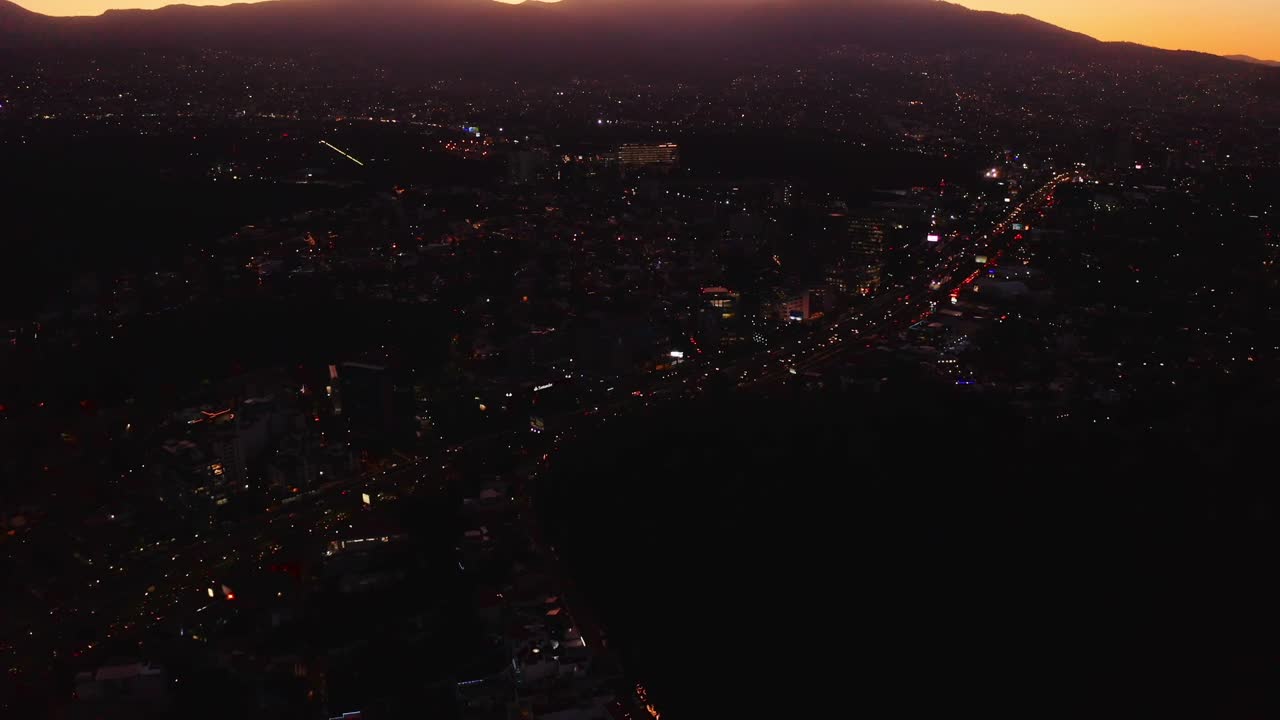 cielos rosados al amanecer sobre una carretera oscura y transitada con tráfico en la ciudad de méxico, por la noche
