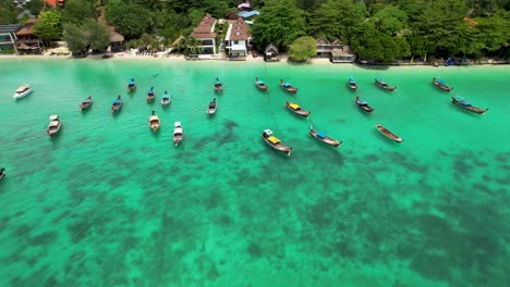 tailandia barcos de cola larga anclados por la playa en hermosas aguas tropicales azules vuelo aéreo en