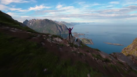 hiker woman standing with hands up achieving the top