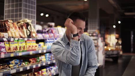 man in supermarket dancing with shopping trolley. positive dances in an empty food store