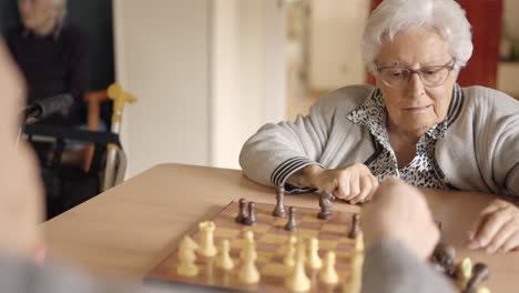 Senior friends playing chess in a nursing home