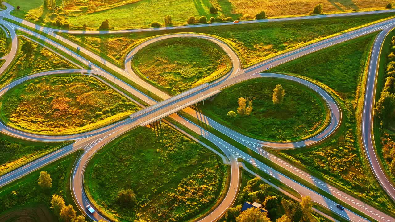 Cloverleaf Highway Interchange With Curved Roads and Cars in Sunset Light